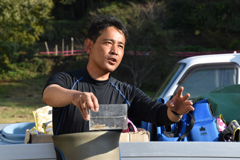 子どもたちに魚の説明をする九州大学の鬼倉徳雄先生。先生はWWFジャパンが取り組む、水田・水路の自然を守るプロジェクトのパートナーでもあります。