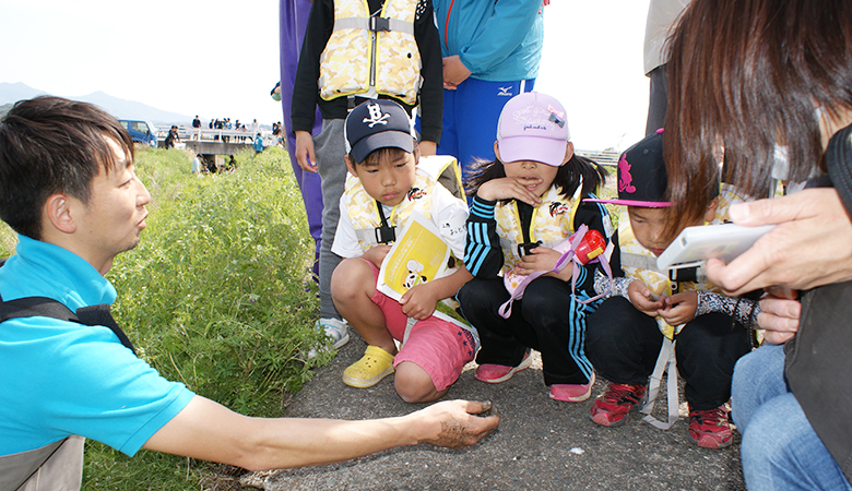 参加した子供たちが捕った二枚貝を手に持ち、子どもたちに説明する林先生。この後二枚貝は水路に戻しました。