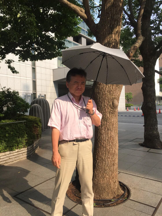 裏側がチェックになっているお洒落な日傘をさす環境省の鮎川氏