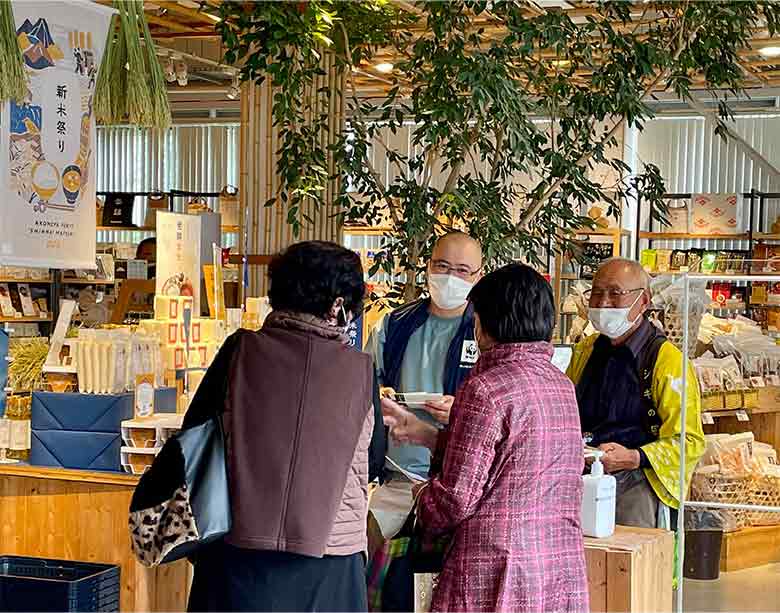 試食販売の会場で消費者と交流する推進協議会のメンバーとWWFスタッフ